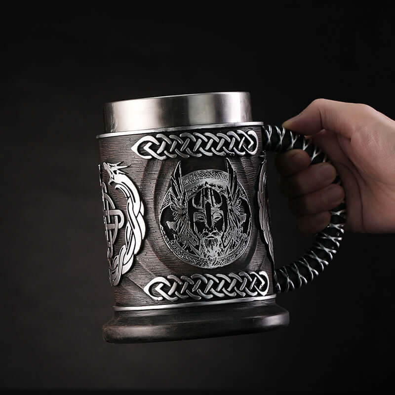 Hand holding a minimalist beer mug with intricate Viking design, perfect for stylish beverage enjoyment.